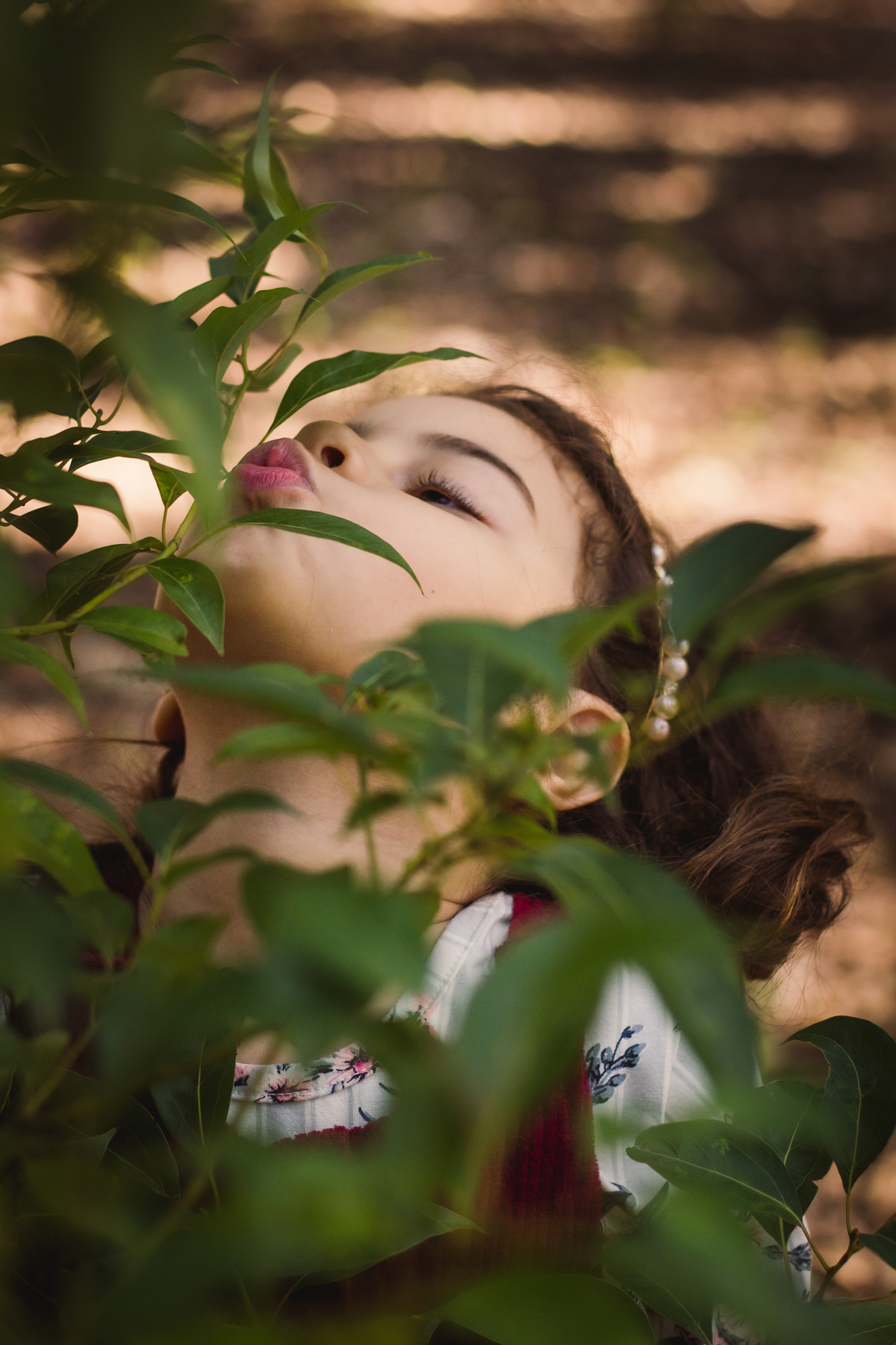 menina dando beijo numa árvore