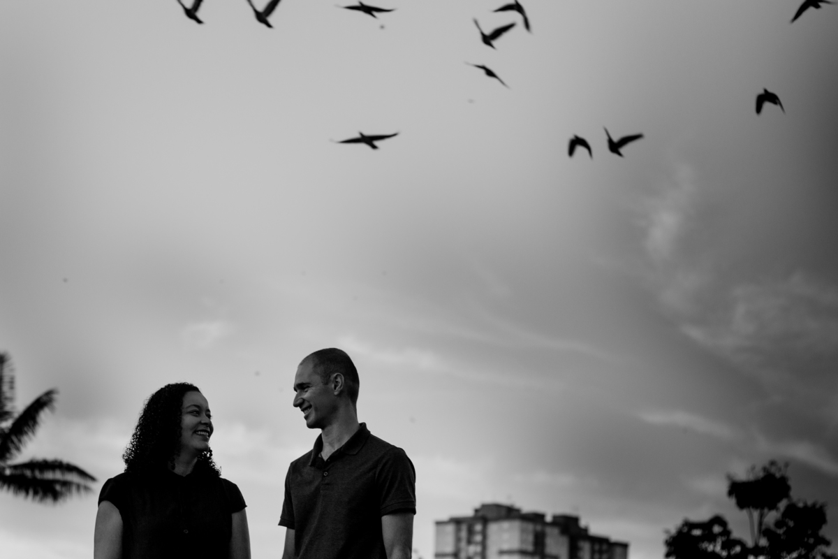 casal em parque com pássaros voando