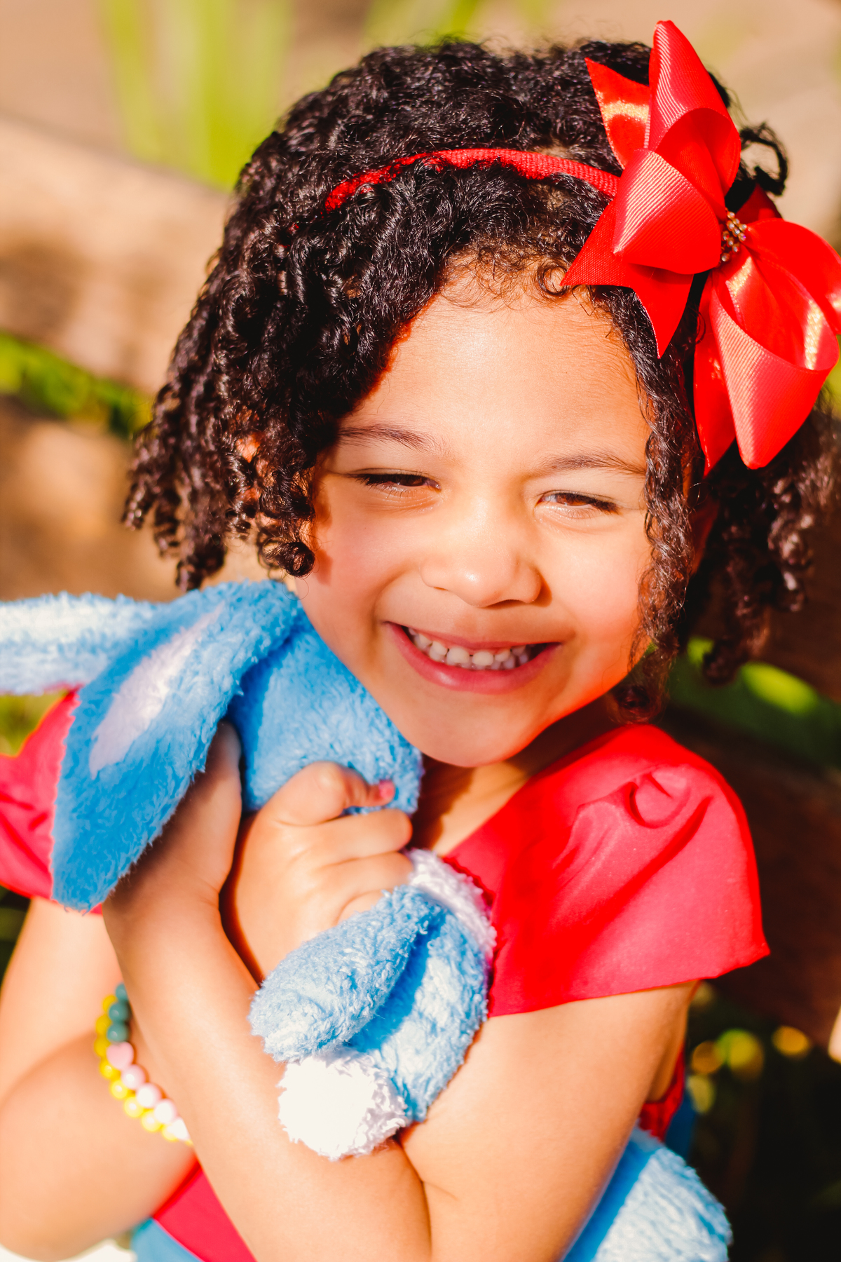 menina de cabelos cacheados abraçando o sansão 