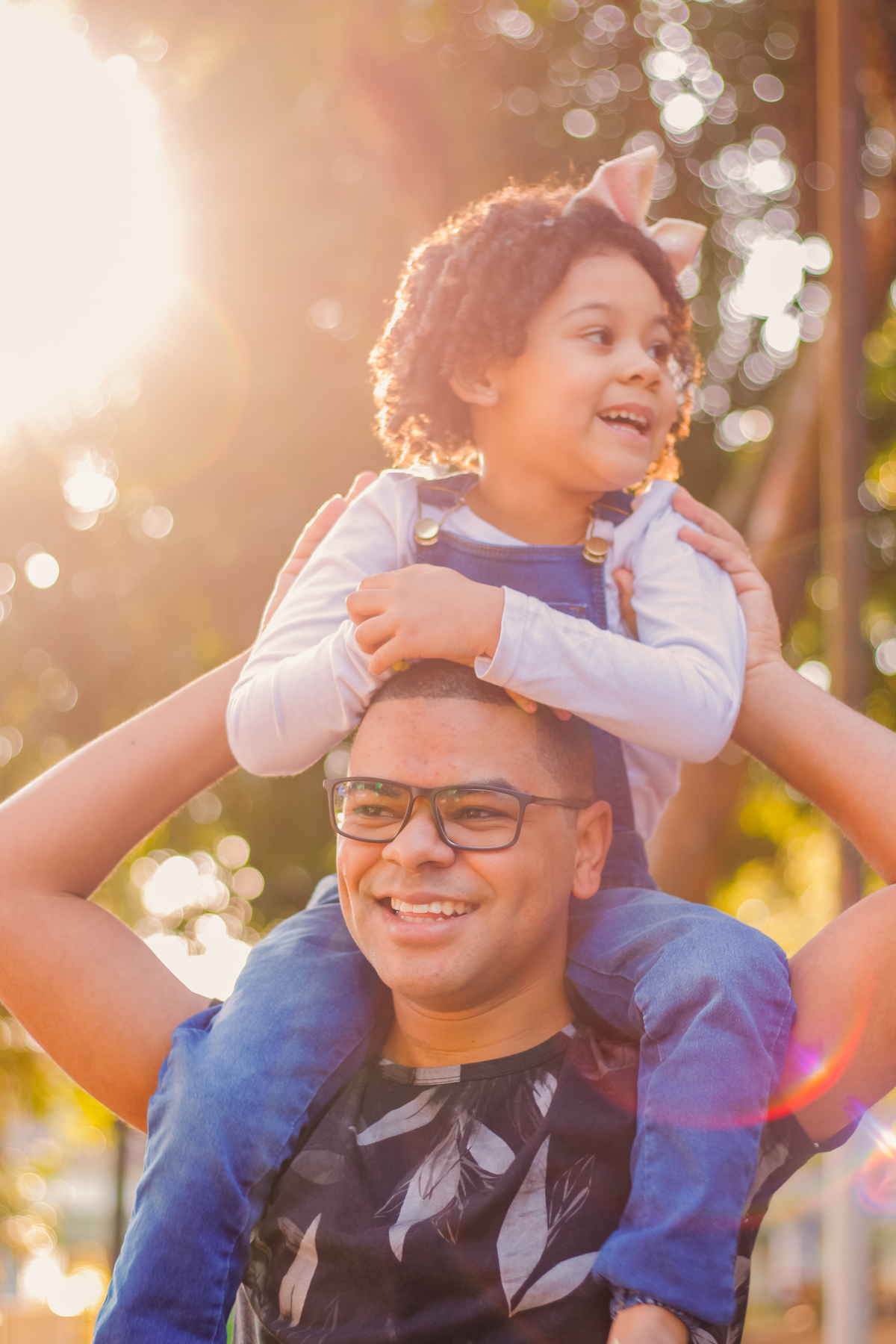 pai segura filha em cima dos ombros 