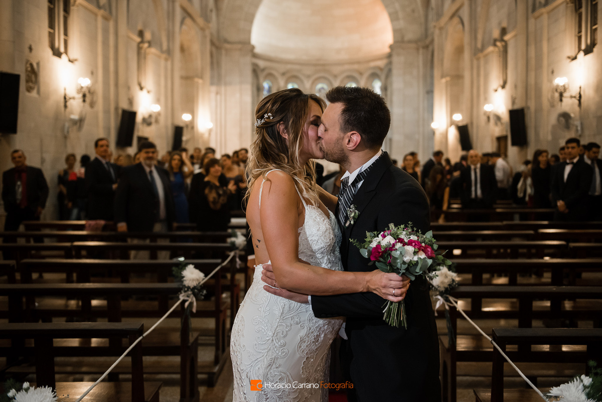 beso de los novios durante la ceremonia en Parroquia Nuestra Señora de la Guardia