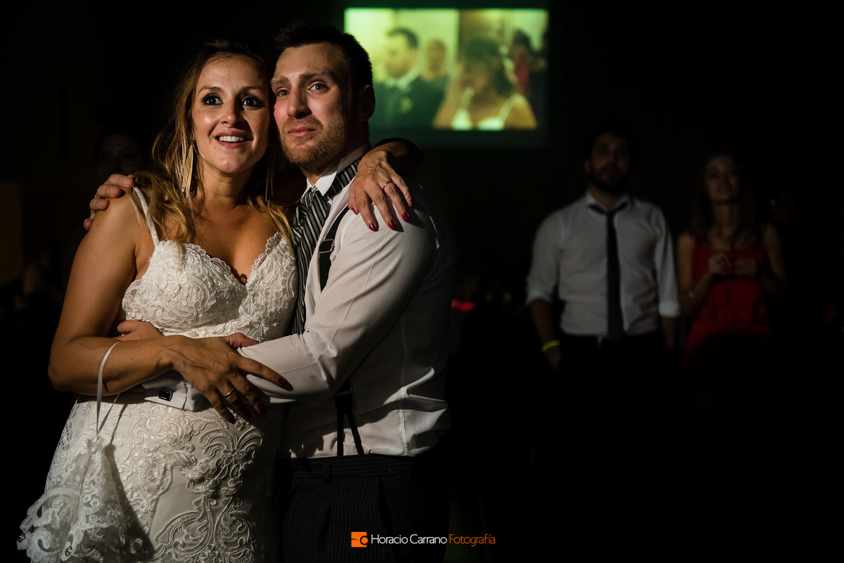  los novios mirando el Video final de Gustavo Longo Videografo en Punto Bahía Eventos