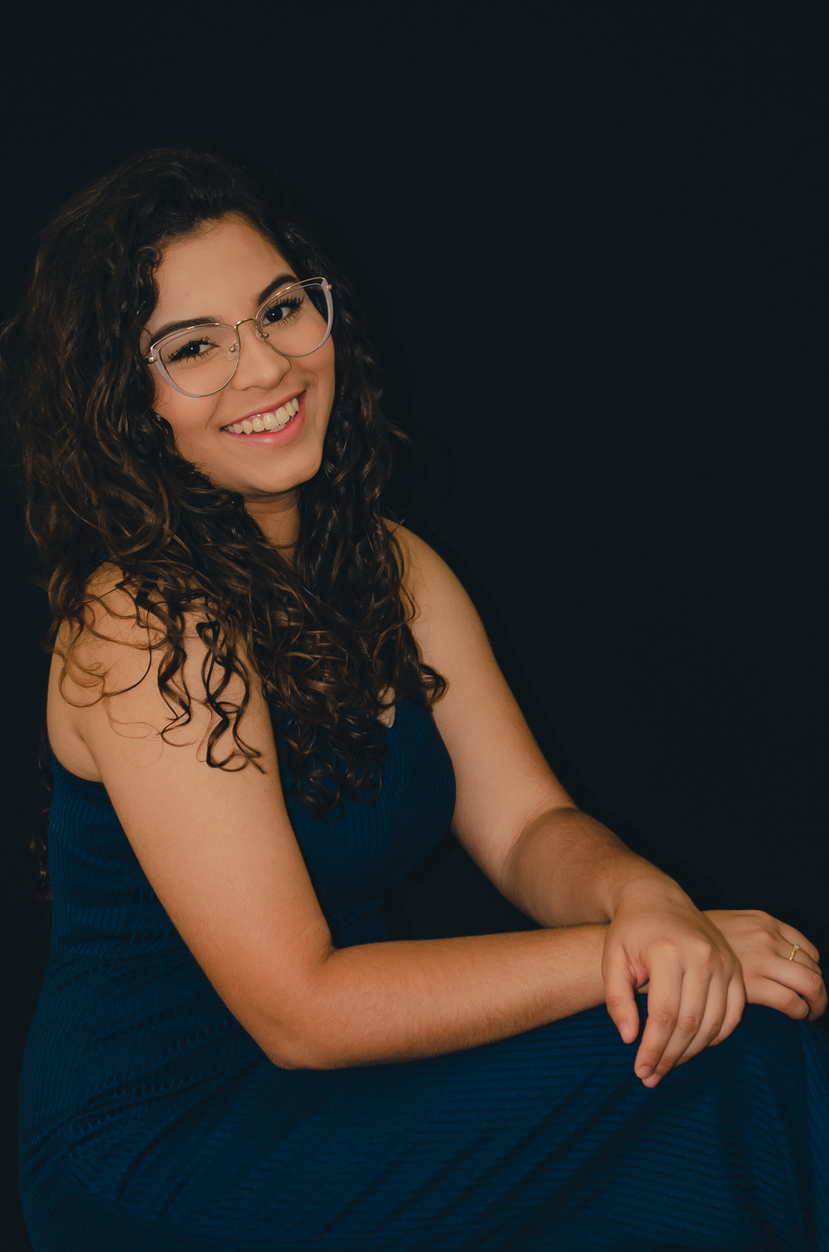 foto feminina estúdio fundo preto sorrindo