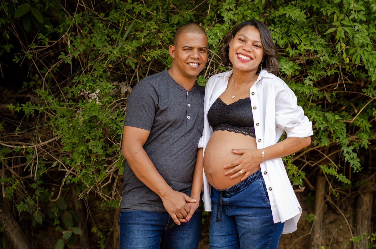 Foto casal gestante externa natureza calça jeans camisa branca meio corpo
