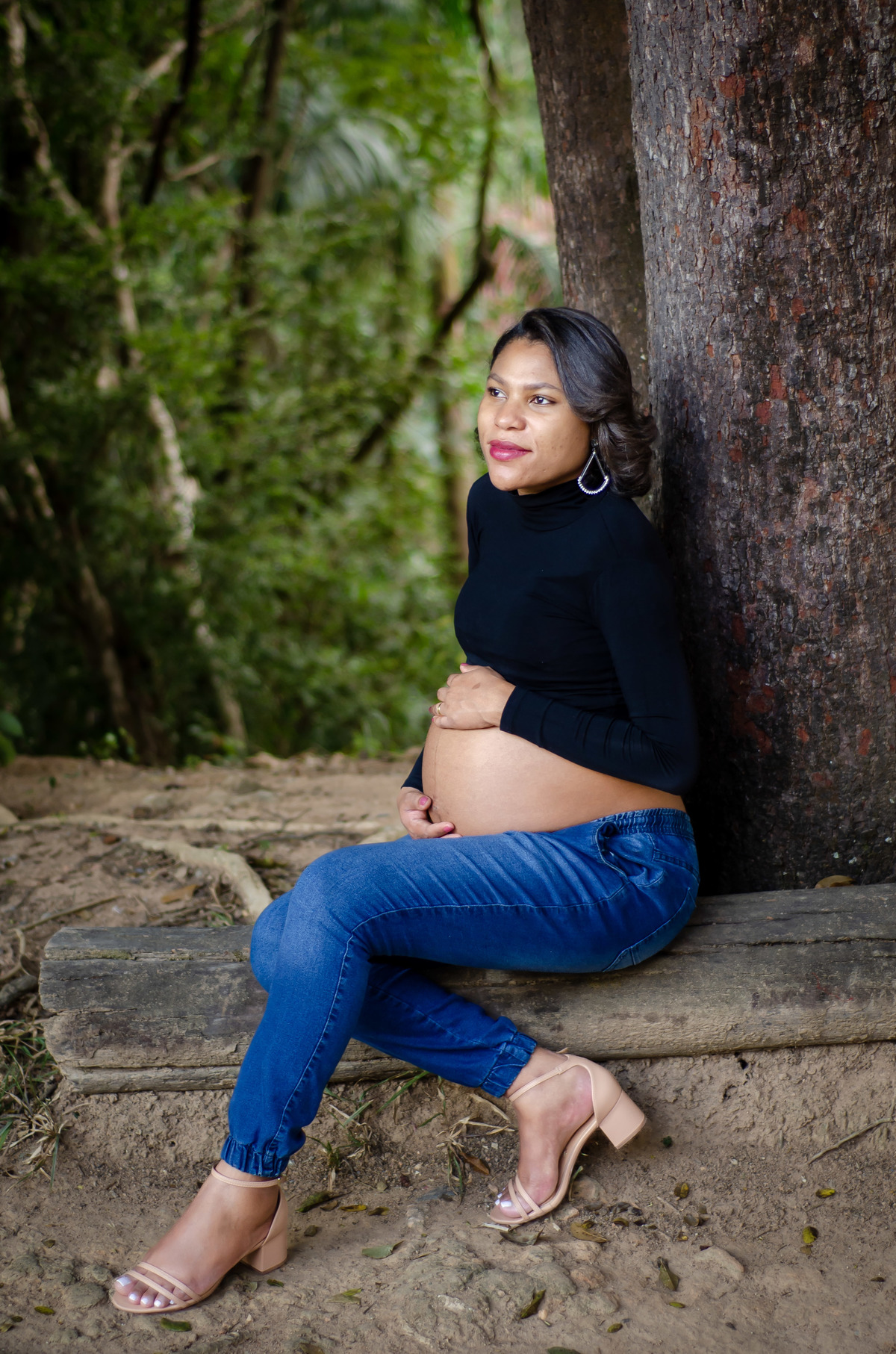Foto gestante sentada natureza externa preto e jeans