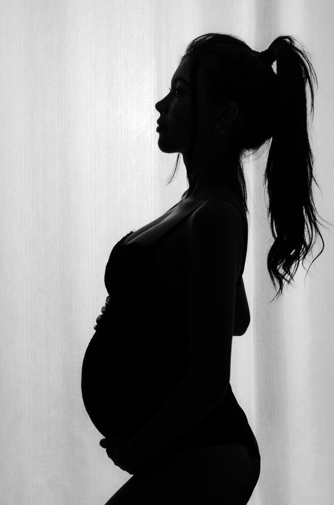 Foto gestante silhueta rabo de cavalo janela cortina branca 