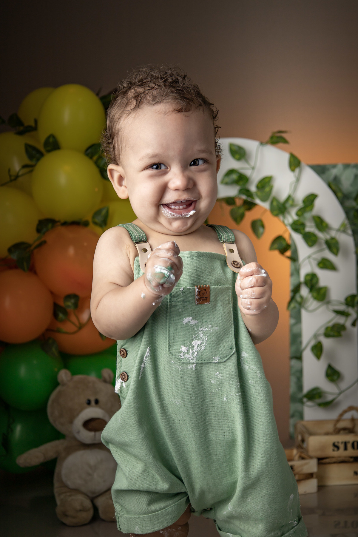 Ensaio fotografico infantil smash the cake, menino sorrindo sujo de bolo, tema safari  
