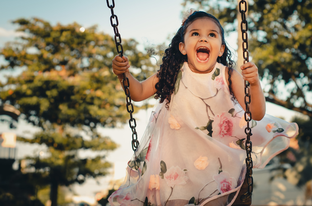 Fotografia Infantil espontânea criança sorrindo brincando em balanço infantil na pracinha Belo Horizonte Praça Sinimbu