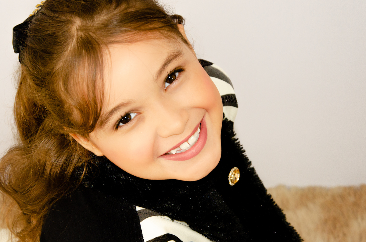 Ensaio infantil em estudio belo horizonte sorriso fundo branco sentada