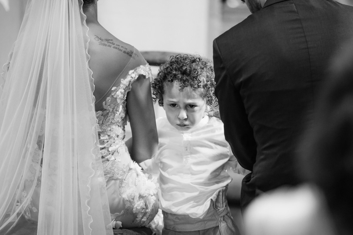 filho dos noivos entra na igreja com os pais