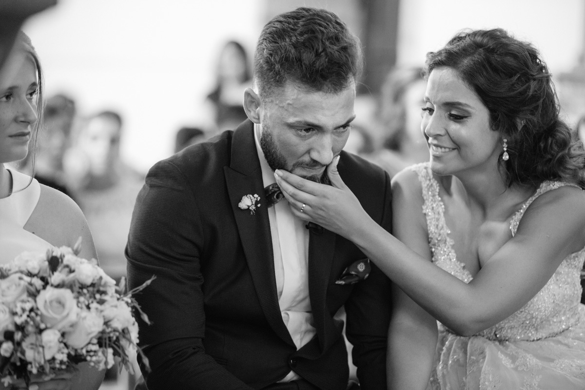 groom cries during the wedding and the bride cleans his tears