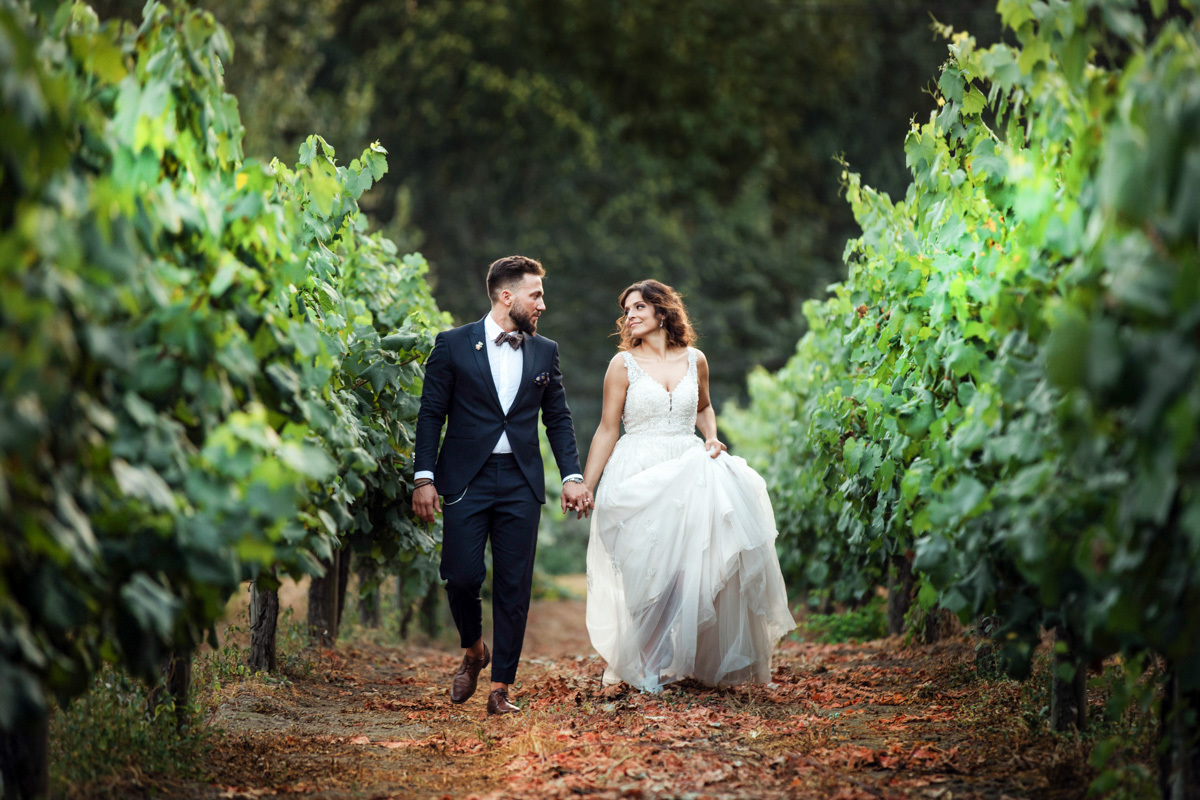 bride and groom walk while holding their hands