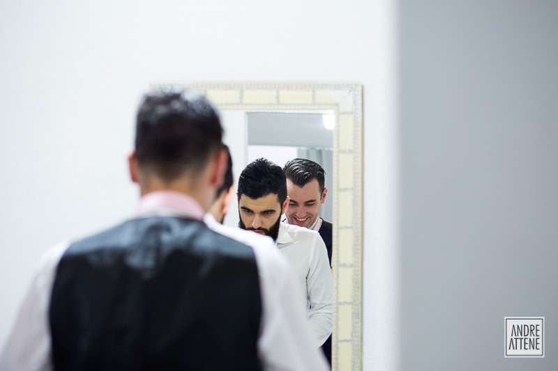 noivo com seu irmão em frente ao espelho conversam espontaneamente em fotografia de Andre Attene
