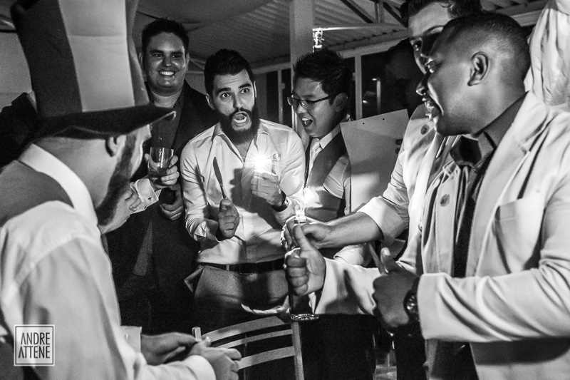 amigos do noivo no momento do corte da gravata muito animados durante a festa de casamento