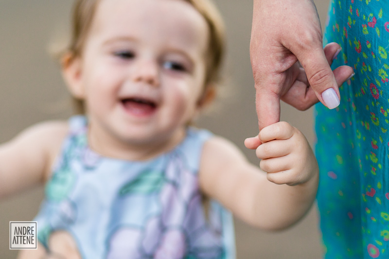 menina sorrindo ao segurar a mão da mamãe