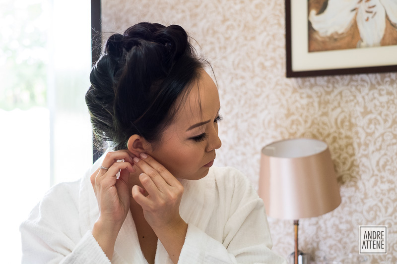detalhe da noiva colocando seu brinco momentos antes do casamento