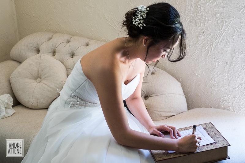 noiva escreve seus votos em fotografia de Andre Attene