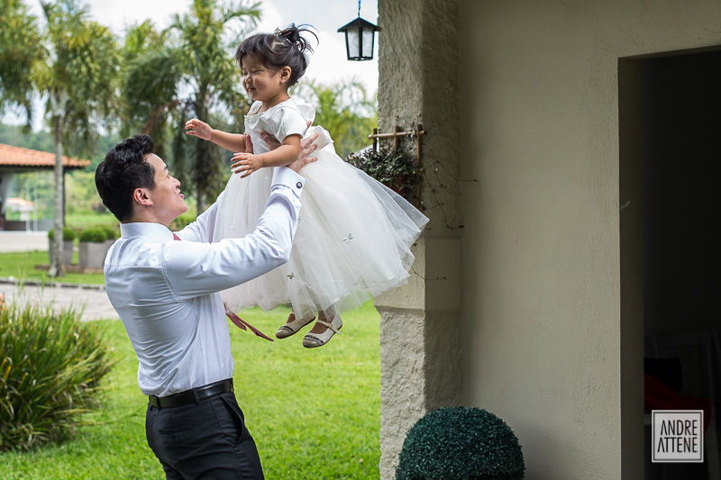 padrinho no noivo brinca com menininha momentos antes do casamento de seu amigo.