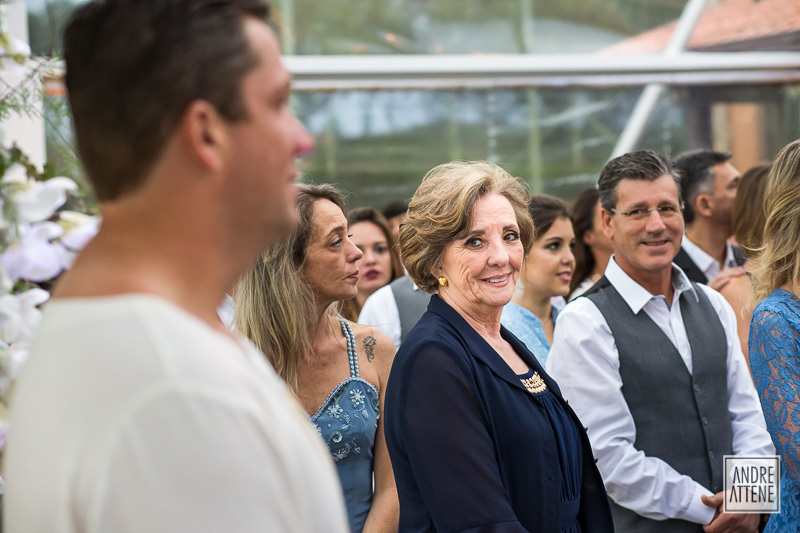 a mãe do noivo o olha, com um sorriso encantador e natural, fotografados por Andre Attene