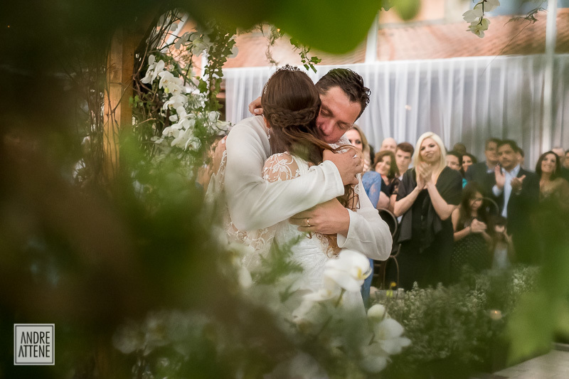 após o beijo, o noivo abraça carinhosamente sua noiva em fotografia espontânea de Andre Attene