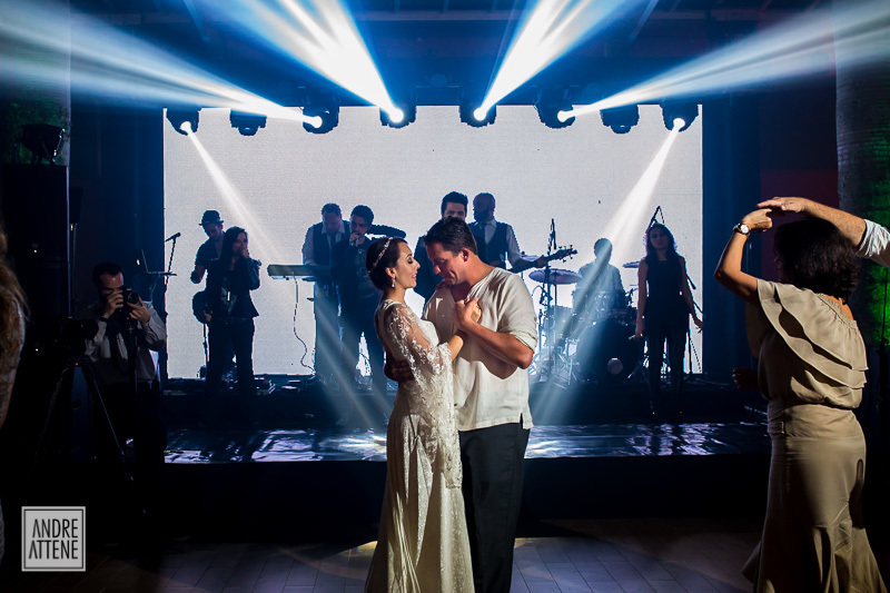 A banda toca enquanto os noivos dançam em sua festa de casamento fotografados por Andre Attene