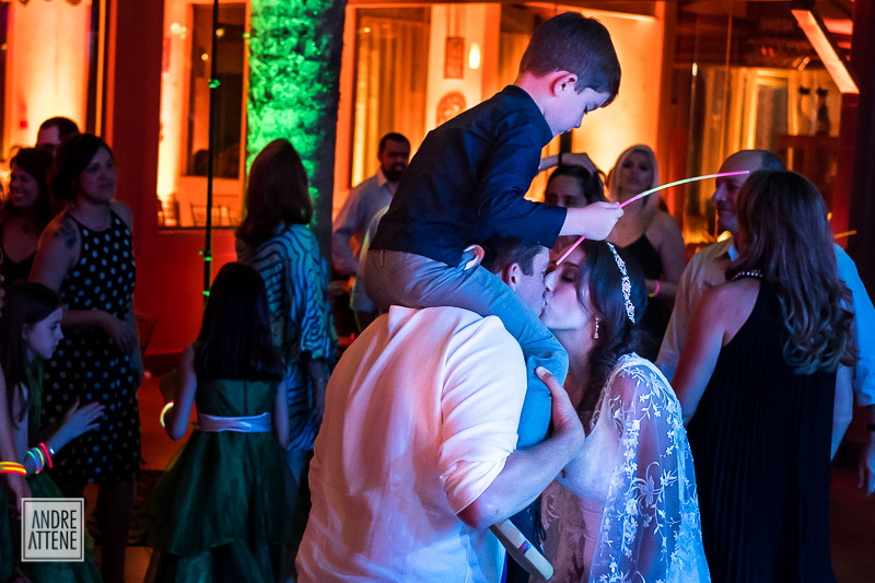 noivos se beijando enquanto noivo carrega seu filho de 