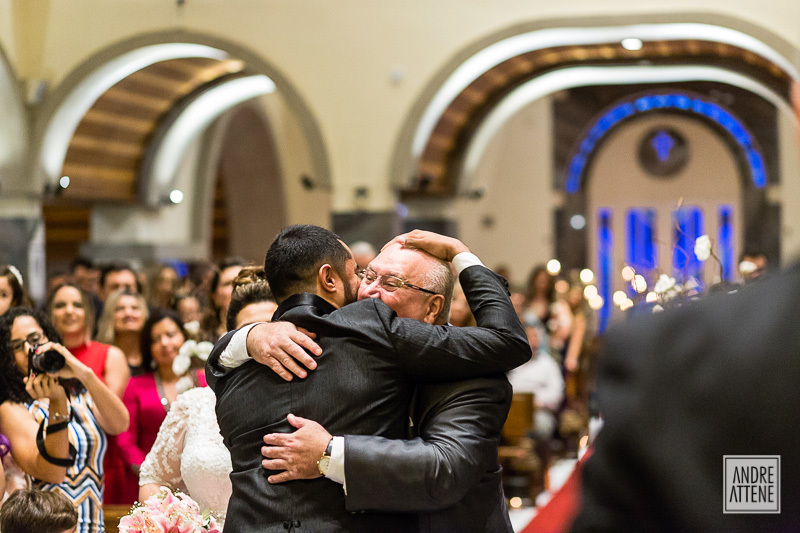 pai da noiva feliz abraça o noivo com emoção em fotografia espontânea de Andre Attene