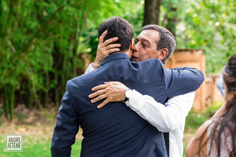pai do noivo o abraça durante sua cerimônia de casamento 