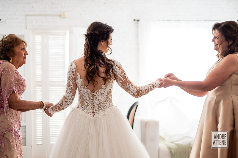 fotografia documental mostra momento espontâneo emocionante entre avó mãe e neta em seu casamento