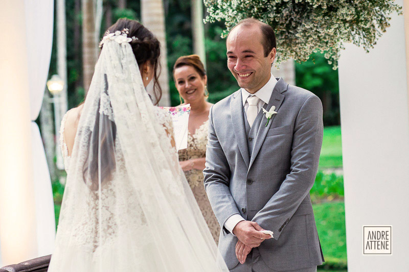 fotografia espontânea mostra o sorriso do noivo e sua madrasta ao ouvir os votos da noiva