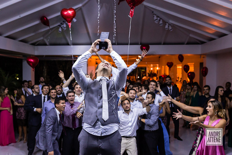 o noivo ameaçando jogar uma caixa de Whisky e os convidados esperam ansiosos e animados