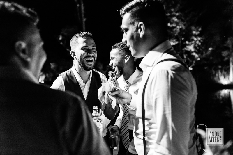 Noivo se diverte com seus amigos enquanto passam a gravata pelos convidados