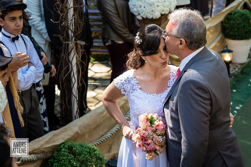 o pai da noiva a entrega ao noivo com um beijo na testa