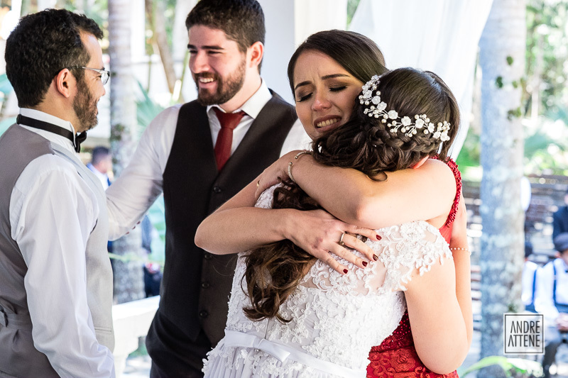 uma das madrinhas da noiva a abraça em fotografia espontânea