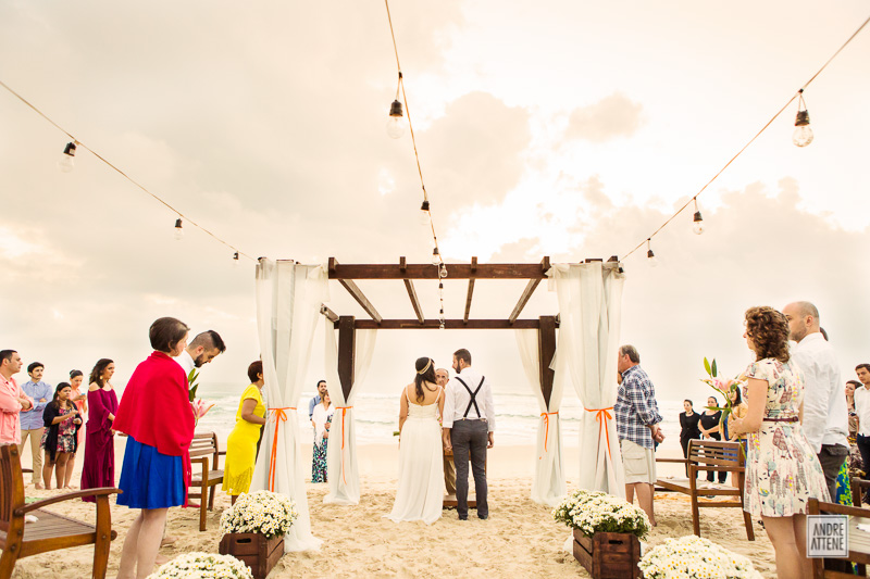 noivos em sua cerimônia na praia com pé na areia fotografados por Andre Attene