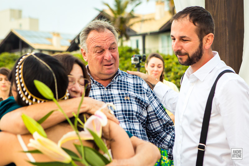 família emocionada se cumprimenta no casamento na praia fotografado por Andre Attene