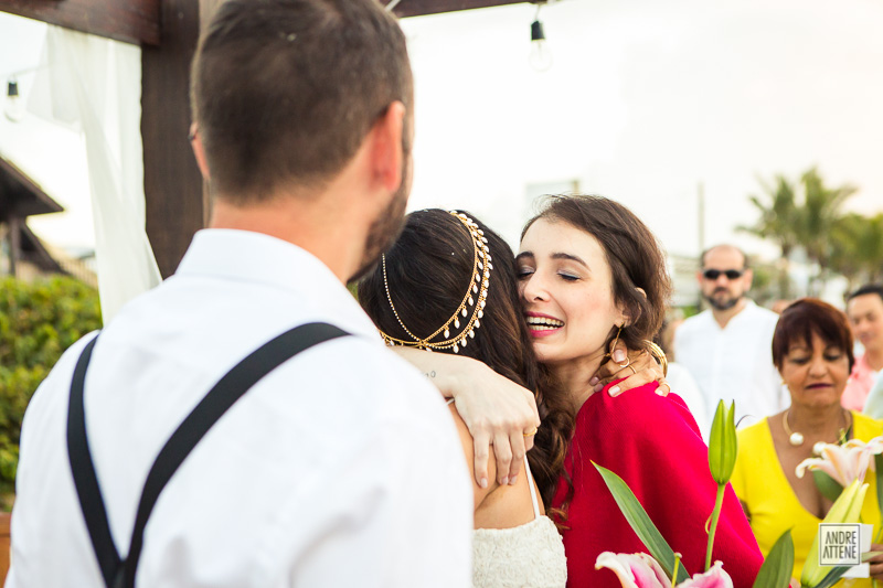 madrinha da noiva com muita emoção abraça a noiva em fotografia de Andre Attene