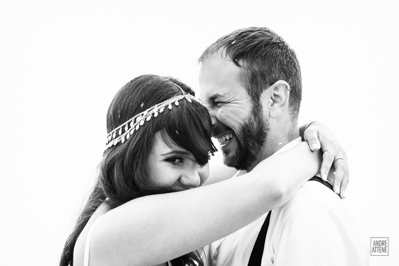 noivos se abraçam em fotografia espontânea de Andre Attene de casamento na praia