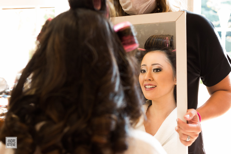 a noiva se admira no espelho em fotografia de casamento natural de Andre Attene