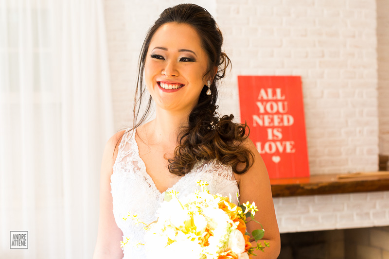 noiva pronta para seu casamento, com seu sorriso natural ao lado da placa que diz 