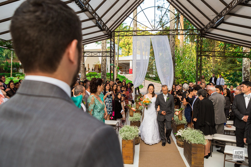 noiva entra com seu pai enquanto seu noivo espera ansioso em fotografia de Andre Attene, fotógrafo em São Paulo