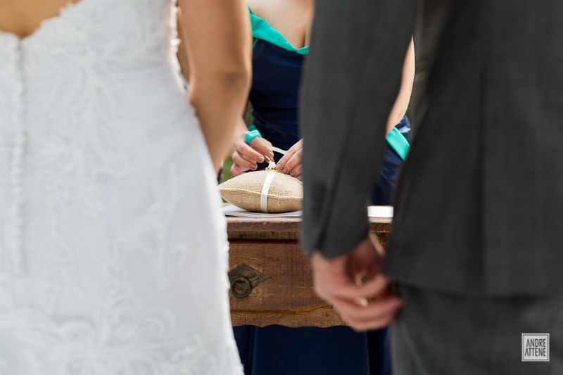 celebrante prepara alianças que vieram em almofada rústica