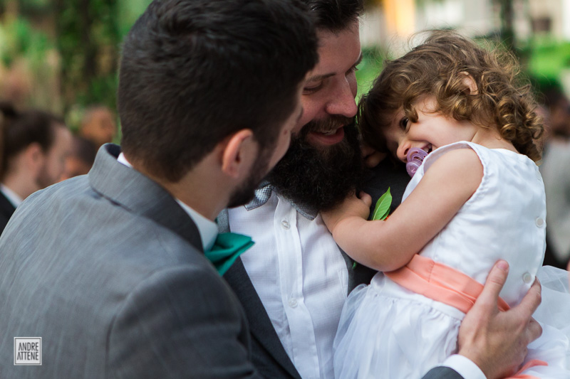irmão do noivo com sua sobrinha no colo cumprimentam noivo em fotografia sensível e singela de Andre Attene na fazenda 7 lagoas em São Paulo