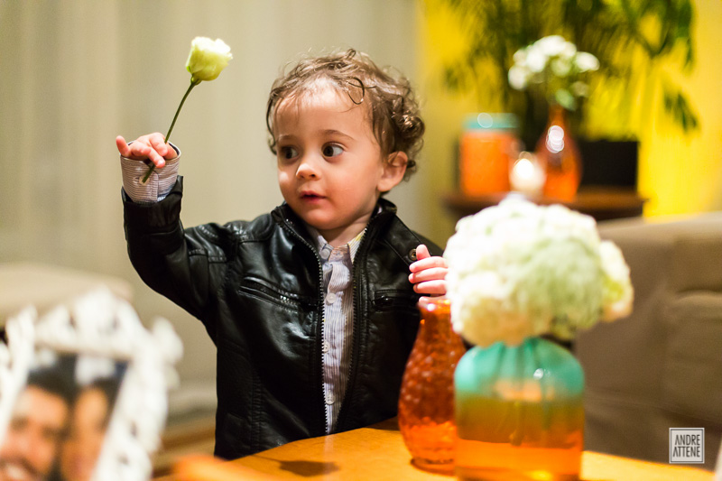 criança brinca com flores no casamento de Erika e Pedro na fazenda 7 lagoas em SP na fotografia de Andre Attene