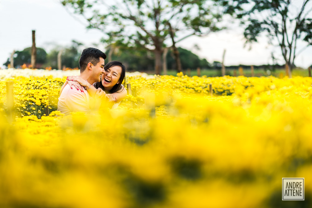 Casal com sorriso espontâneo ao conversar durante ensaio fotográfico clicado por Andre Attene