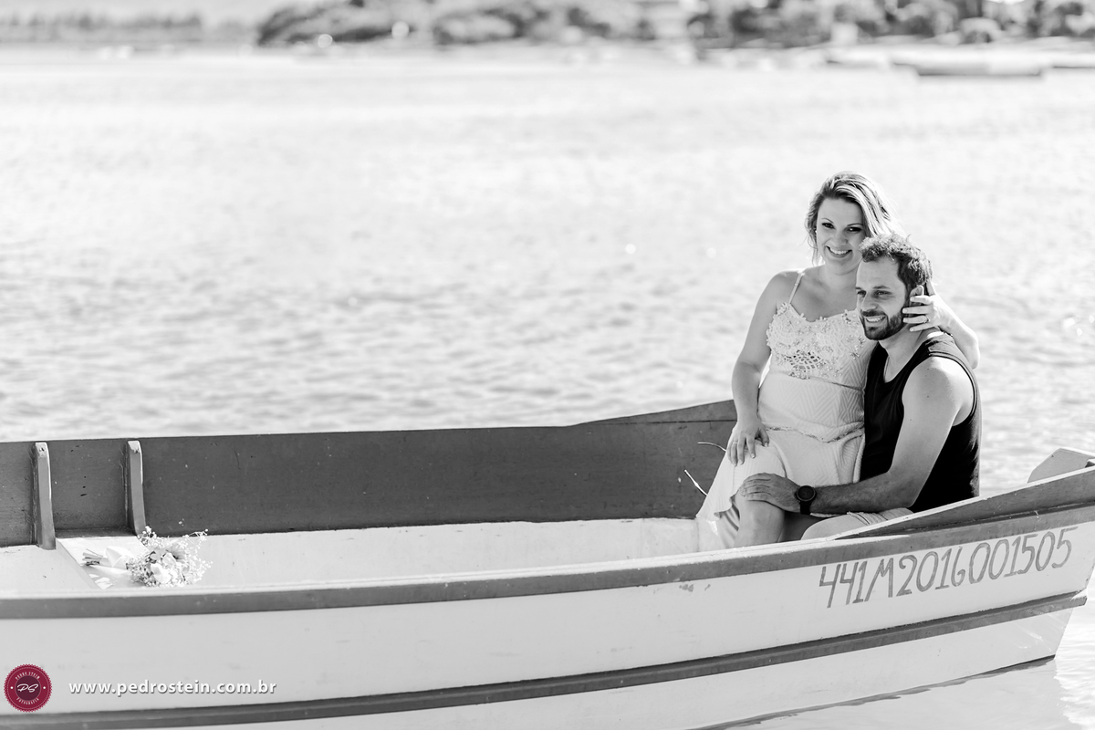 pedro stein fotografo de casamento em pre wedding na guarda do embau com noivos sorrindo em cima de barco olhando para o horizonte