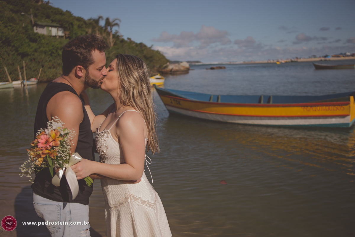 pedro stein fotografo de casamento em pre wedding na guarda do embau com noivos se beijando com barco ao fundo