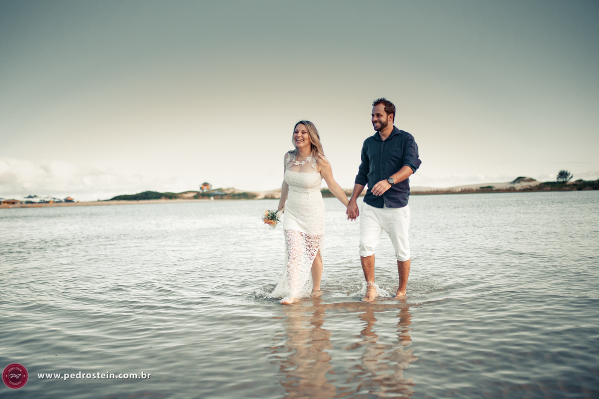 pedro stein fotografo de casamento em pre wedding na guarda do embau com noivos  caminhando e sorrindo na beira da praia