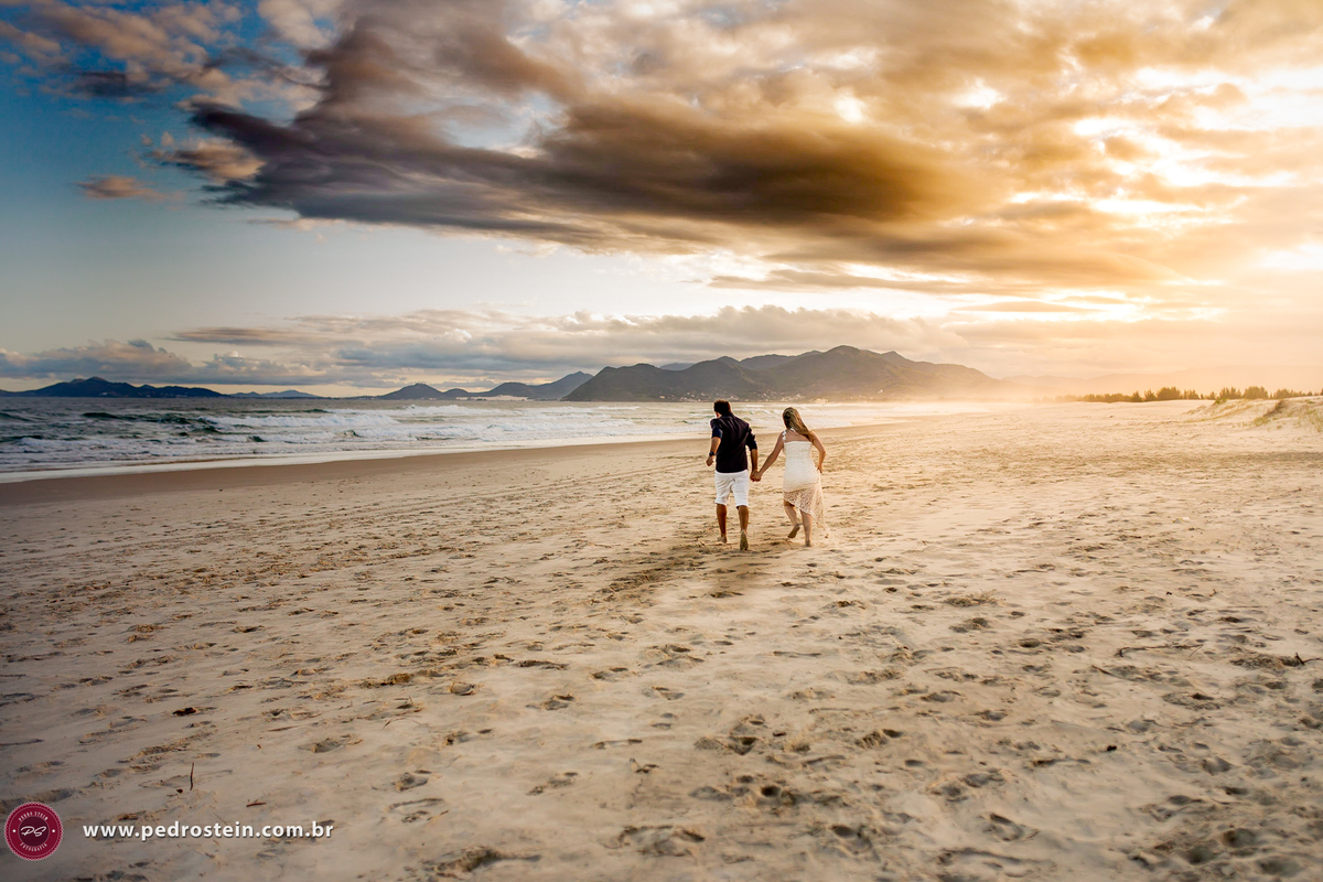 pedro stein fotografo de casamento em pre wedding na guarda do embau com noivos correndo em direção ao mar