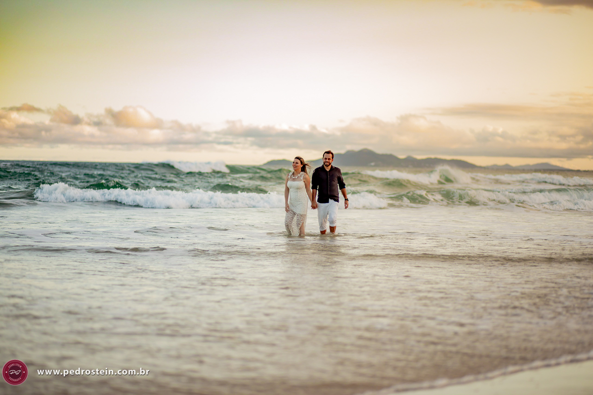 pedro stein fotografo de casamento em pre wedding na guarda do embau com noivos caminhando dentro do mar